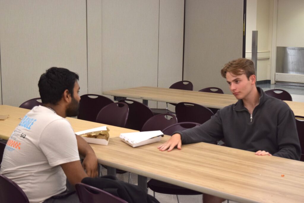 Photo of two friends sharing pizza in the cafeteria